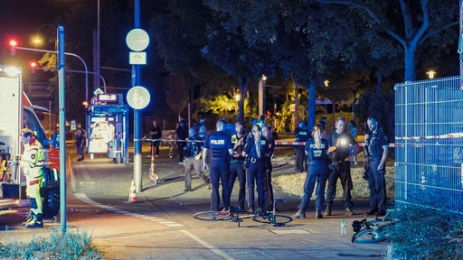 Polizisten vor und hinter einer Absperrung auf einer Kölner Straße