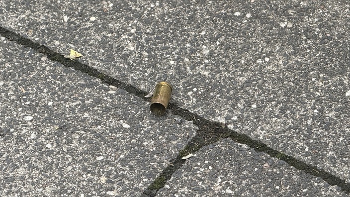 Eine abgeschossene Patronenhülse einer Schusswaffe liegt auf dem Boden.
