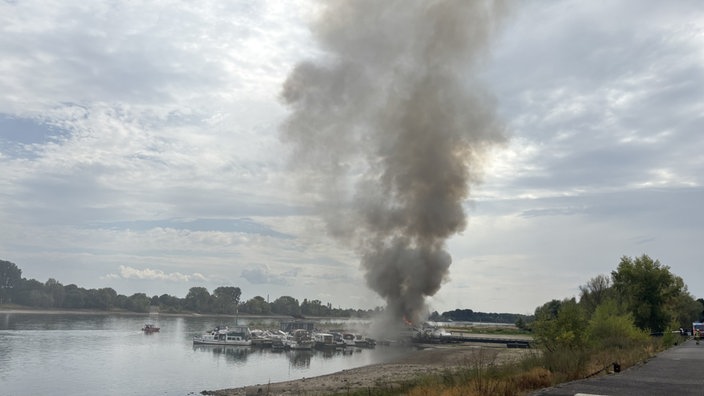 Das Bootshaus in Suerth steht in Flammen. Eine dichte Rauchwolke ist zu sehen.