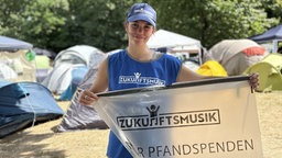 Frau vom Projekt "Zukunftsmusik" hält eine Mülltüte in den Händen
