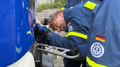 Michael Ciupke befestigt das Anschlagstück an einem Fahrzeug.
