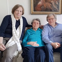 Die Tochter der Mieterin, die Mieterin selbst, der Sohn und die Schwiegertochter sitzen auf dem Sofa.