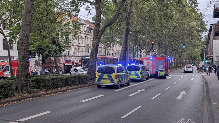 Einsatzfahrzeuge von Polizei und Rettungswägen stehen rund um die Unfallstelle in Köln-Sülz