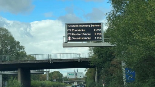 Ein digitales Schild zeigt bei Köln Stauzeiten an.