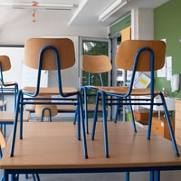 Stühle stehen in einer Schule auf den Tischen.