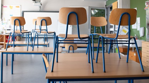 Stühle stehen in einer Schule auf den Tischen
