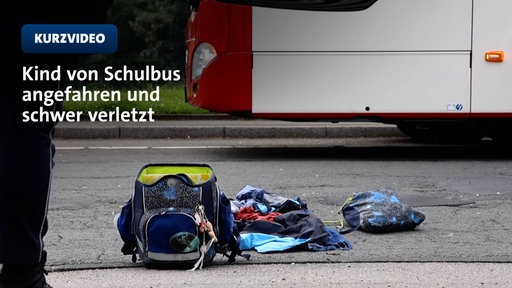Schulrucksack auf der Straße vor einem Bus