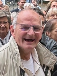 Der Postbote Martin Herstelle ist von Menschen umgeben und lacht in die Kamera.