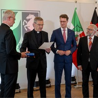 Bischof Wilmer legt seine Hand auf die Bibel und liest einen Treueeid ab.