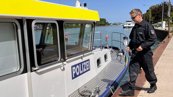 Marc Englbrecht, Wasserschutzpolizei Wache Münster, geht auf sein Einsatzboot am Kanal.