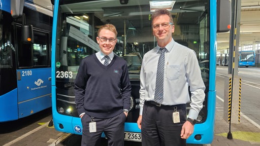 zwei Personen vor einem Bus
