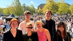 Sechs Jugendliche stehen auf dem Domplatz vor einem Publikum auf der Bühne und lächeln in die Kamera.