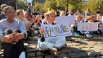 Schülerinnen und Schüler halten Plakate hoch.