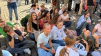Die Schülerinnen und Schüler auf dem Domplatz mit aufgemalten Regenbogen-Flaggen im Gesicht.