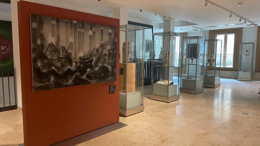 Ausstellungsansicht mit Bildern und Vitrinen