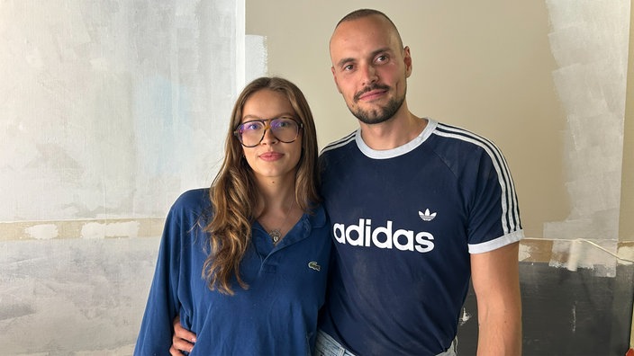 Ein Mann und Frau stehen Arm in Arm nebeneinander 