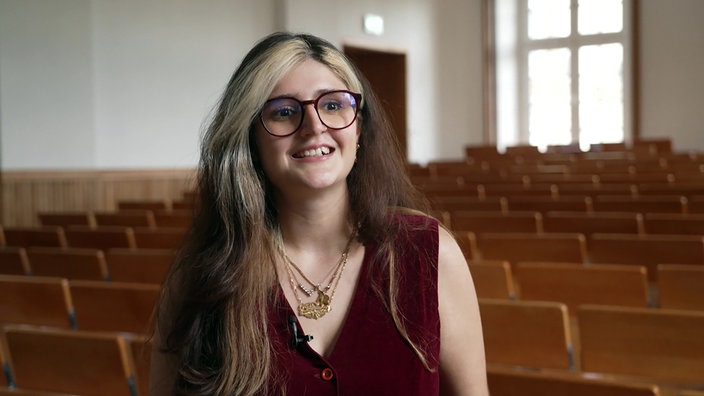 Eine Studentin wird im Hörsaal interviewt.