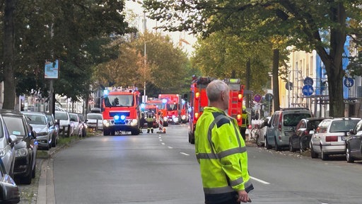 Mehrere Feuerwehrautos im Einsatz reihen sich auf einer Straße aneinander
