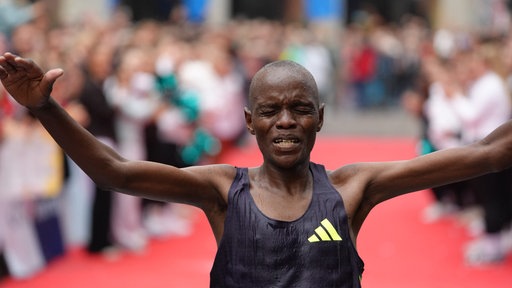 Der Marathon-Läufer Dickson Kiptoo aus Kenia hebt erleichtert die Arme beim Einlaufen ins Ziel.