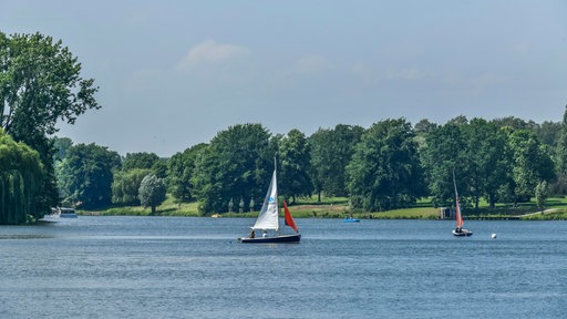 Segelboote fahren auf dem Aasee in Münster bei schönem Wetter.