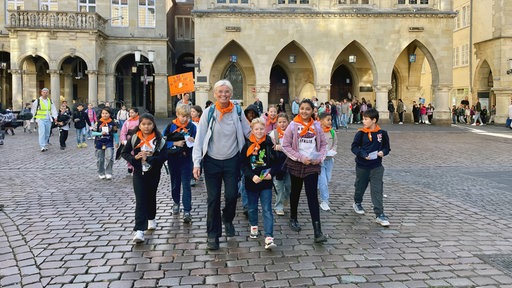 SchülerInnen protestieren vor dem Münsteraner Rathaus mit ihrer Lehrerin für den Frieden.