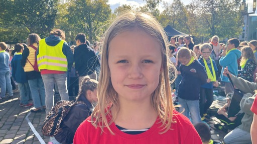 Eine Schülerin auf dem Friedensfest lächelt in die Kamera.