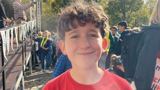 Ein Schüler auf dem Friedensfest lächelt in die Kamera.