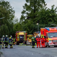 Im Morgengrauen stehen mehrere Einsatzwägen und Einsatzkräfte der Feuerwehr vor einem Haus.