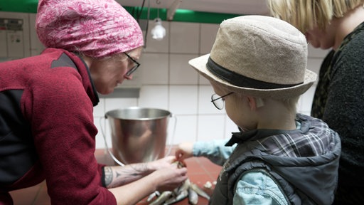 Die Tierpflegerin zeigt Raphael wie das Futter für die Fütterung vorbereitet wird.