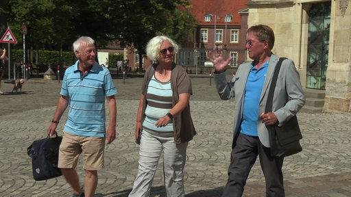 Drei Personen auf dem Domplatz in Münster