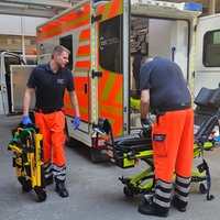 Zwei Männer beladen einen Rettungswagen