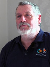 Jürgen Mischke, der Vorsitzende des Bürgerbus e.V. in Merfeld schaut an geradeaus.