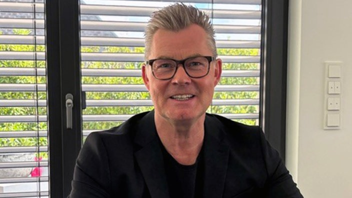 Oliver Hartmann lächelt in die Kamera.