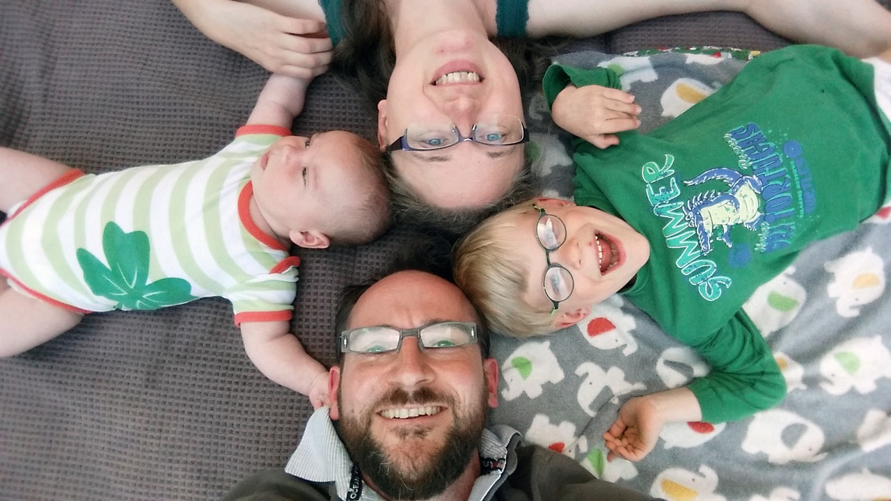 Eine Familie lacht in die Kamera.