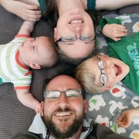 Eine Familie lacht in die Kamera.
