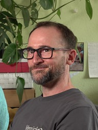 Ein Mann lächelt in die Kamera.