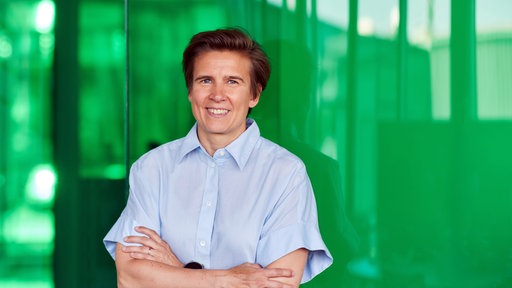 Die Forscherin Sara Wickström vor einer grünen Wand.