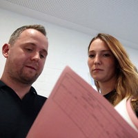 Ein Mann und eine Frau schauen sich einen Aktenhefter an.