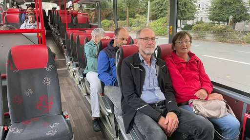 Menschen sitzen in einem Bus.