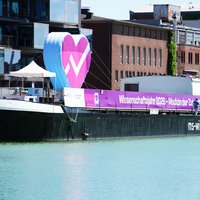 Die MS Wissenschaft liegt am Hafen in Münster. Auf dem Schiff steht ein großes Herz.
