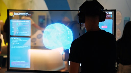  EIn Bescuher schaut sich die Ausstellung auf der MS Wissenschaft an