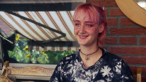 Eine junge Person mit pinken Haaren und Nasenring