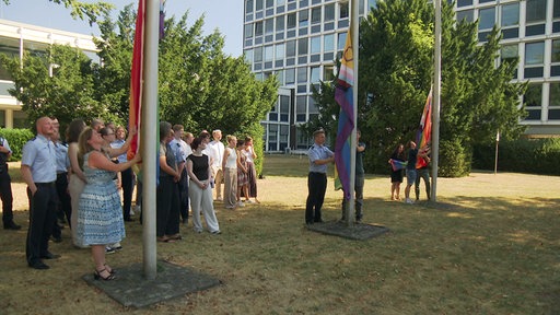 Die Pride-Flaggen werden von Polizisten gehisst