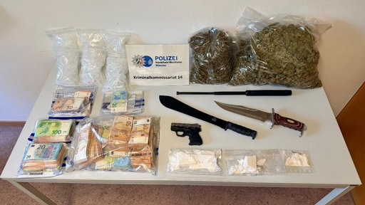 Das Foto zeigt das aufgefundene Gut: Rauschmittel, Waffen und Geld.