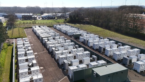 Batteriespeicher in NRW: Auf einer Fläche stehen Batteriespeicherzellen in Reihen.