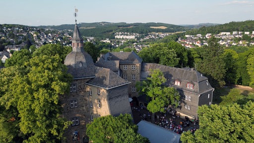 Burg aus Dronenperspektive mit Wald umgeben