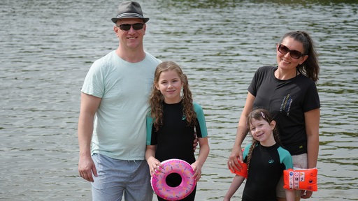 Eine Familie vor einem Badesee.