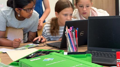 Mädchen sitzen vor einem Laptop und programmieren gemeinsam 
