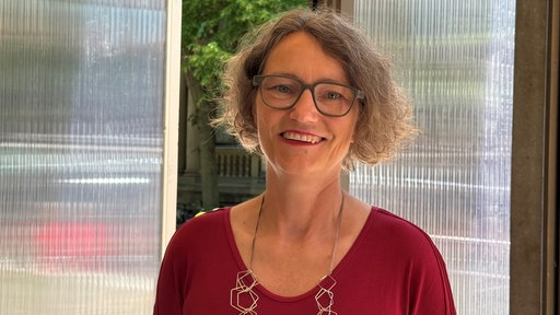 Die das Projekt betreuende Professorin des Projekts steht innerhalb des Recycling-Pavillons.