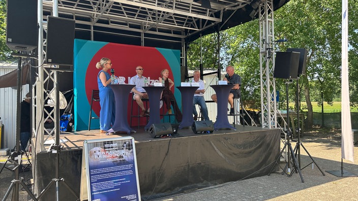 Mehrere Menschen stehen auf einer Bühne